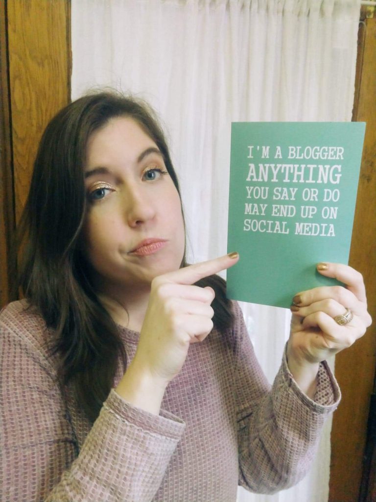 woman holding up notebook and pointing at it